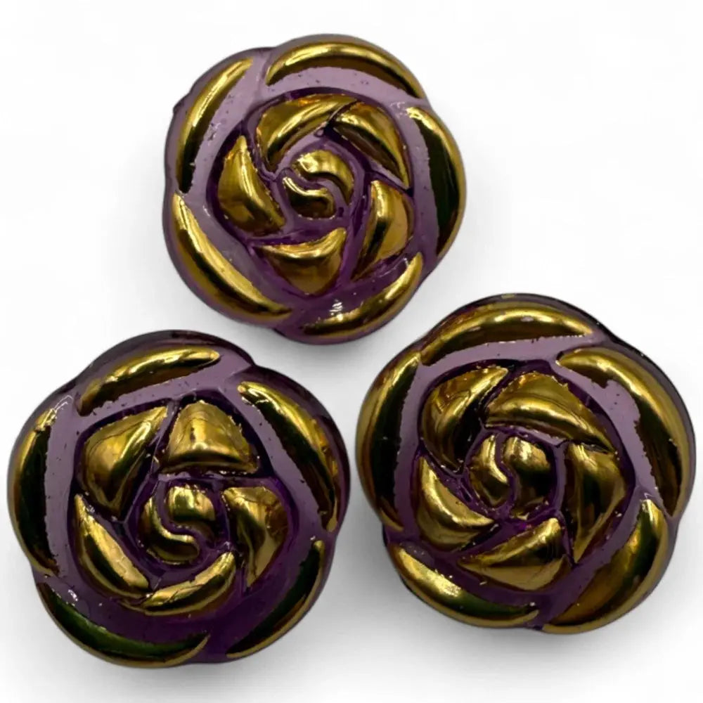 Three purple and gold rose-shaped buttons.