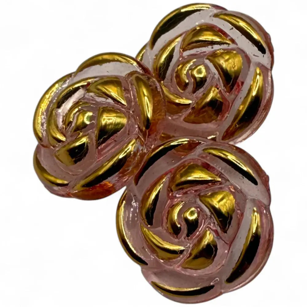 Three pink and gold rose-shaped buttons.