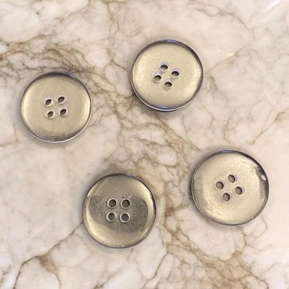 Four silver four-hole buttons.