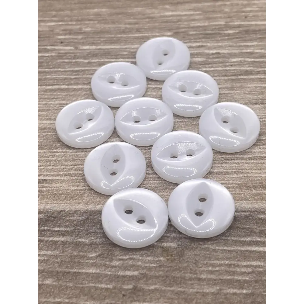 Ten white, round, two-hole buttons.