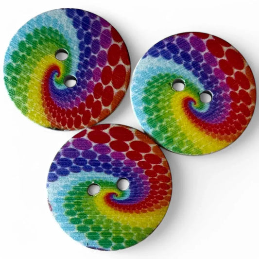 Three colorful tie-dye buttons.