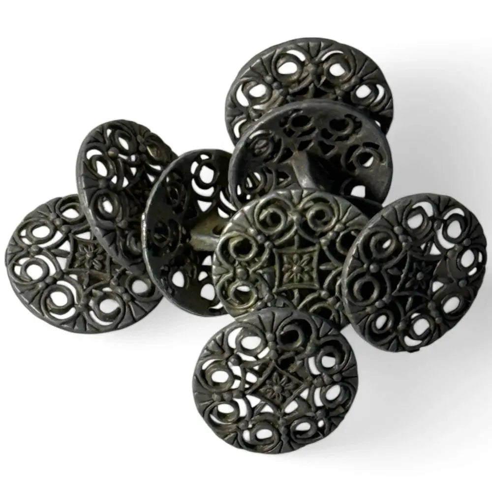 Pile of ornate, dark metal buttons.