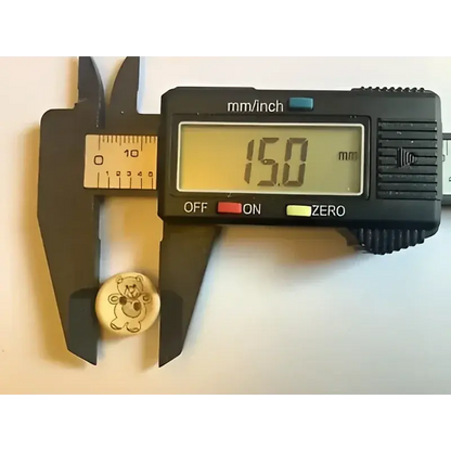 Digital caliper measuring a teddy bear button.