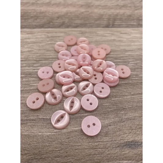 Pile of pink sewing buttons.