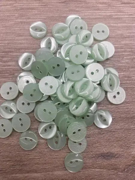 Pile of light green two-hole buttons.