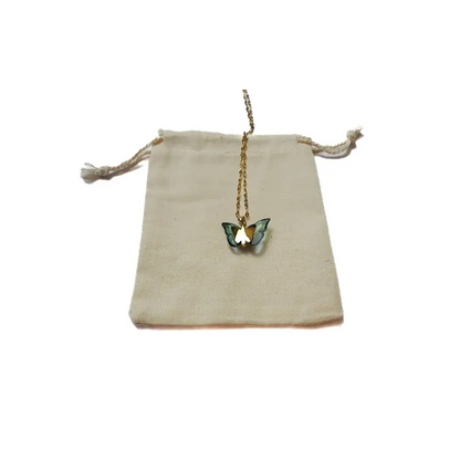Butterfly pendant necklace on a drawstring bag.
