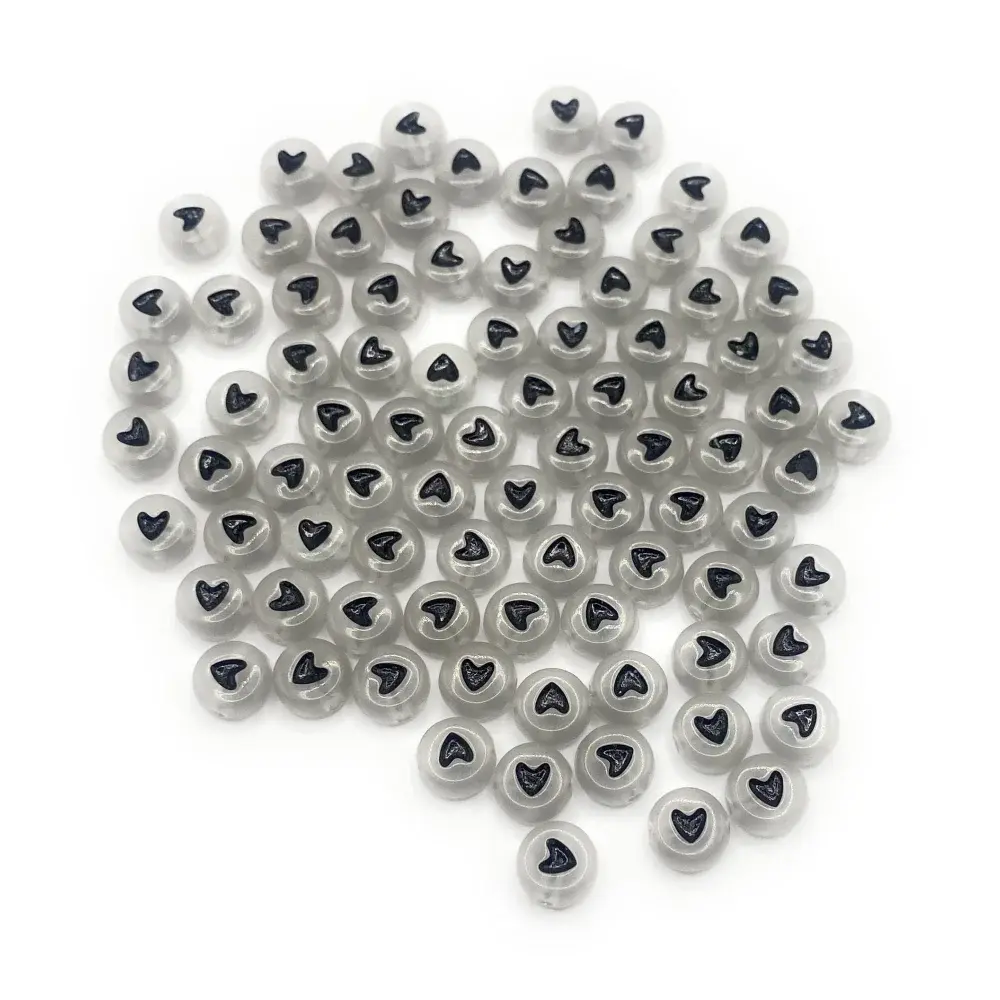 Translucent beads with black heart imprints.