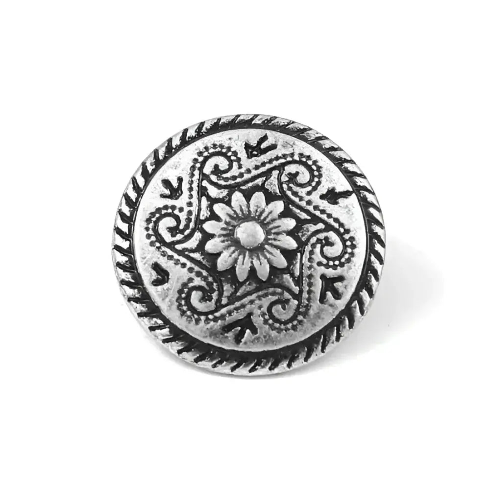 Ornate silver button with floral design.