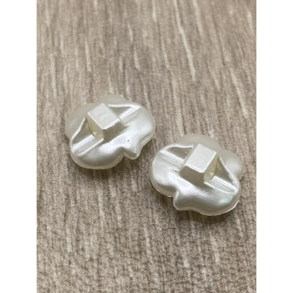 Two pearlescent flower-shaped buttons.