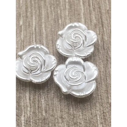 Three silver rose-shaped buttons.