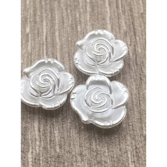 Three silver rose-shaped buttons.