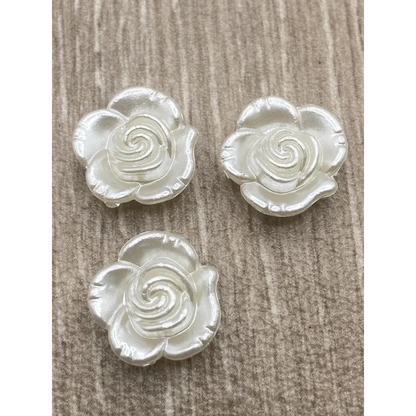 Three pearlescent rose embellishments.
