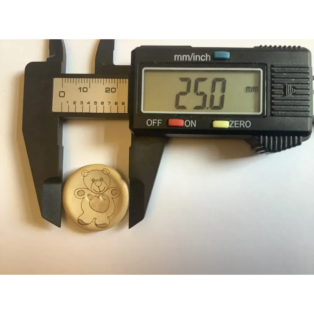 Teddy bear button measured by calipers.