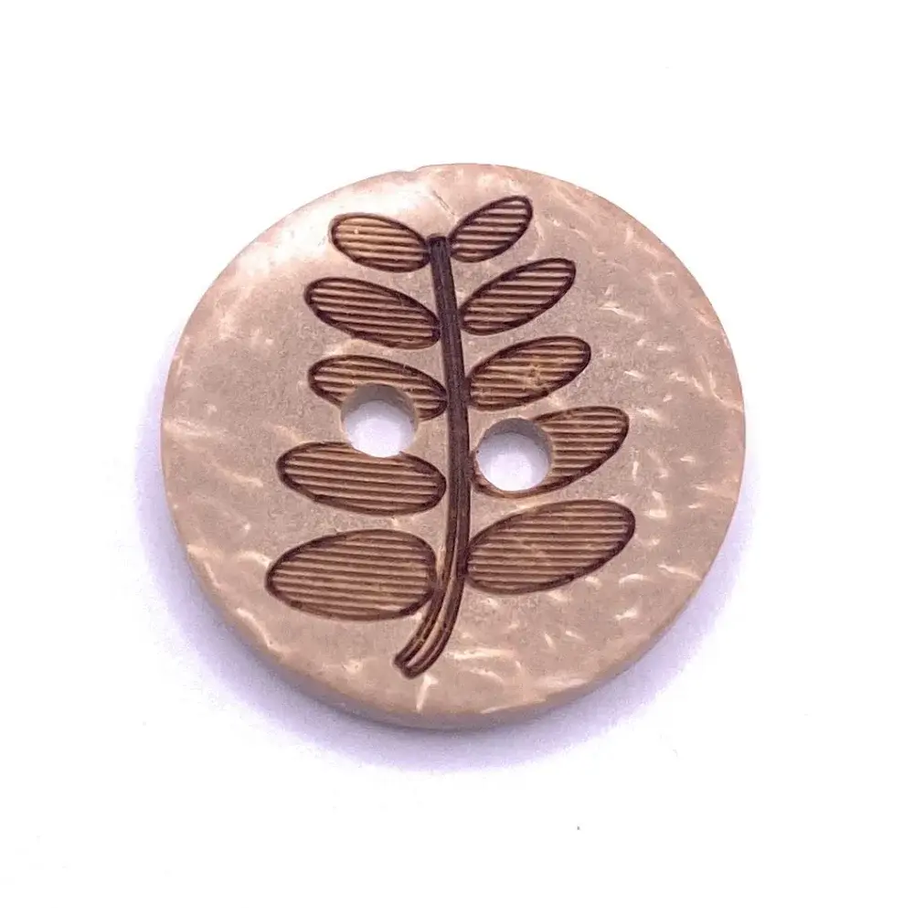 Round, beige button with leaf design.