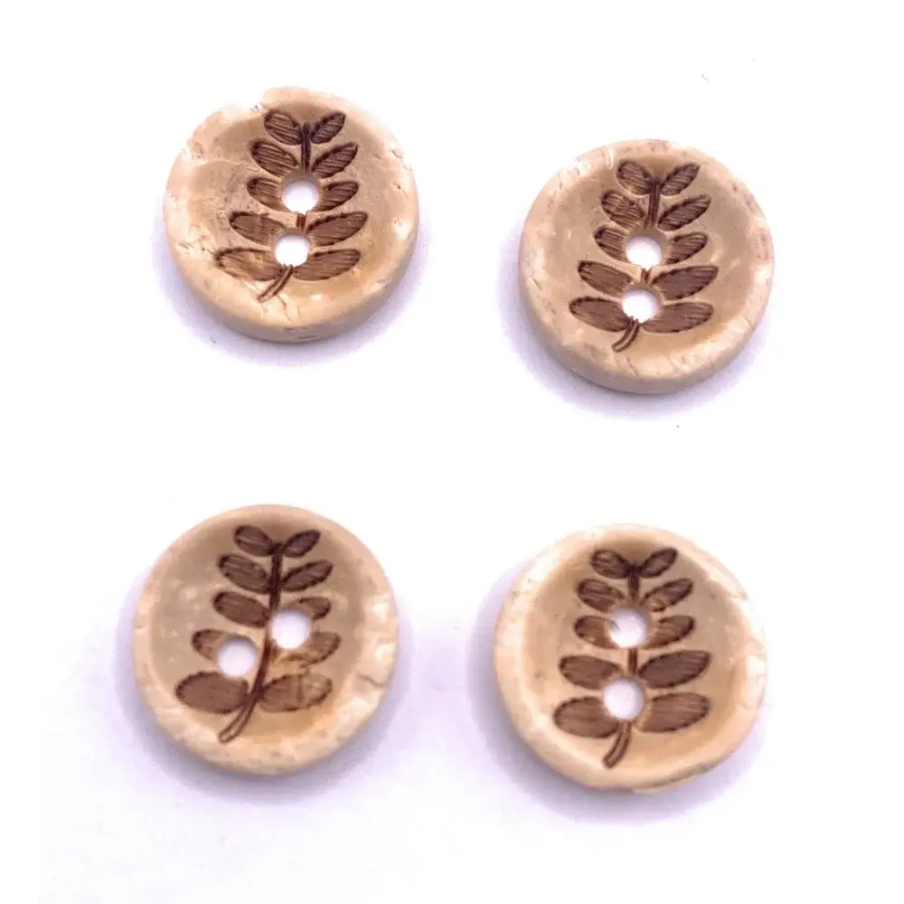 Four round wooden buttons with leaf design.