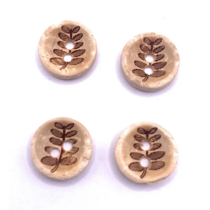 Four round wooden buttons with leaf design.