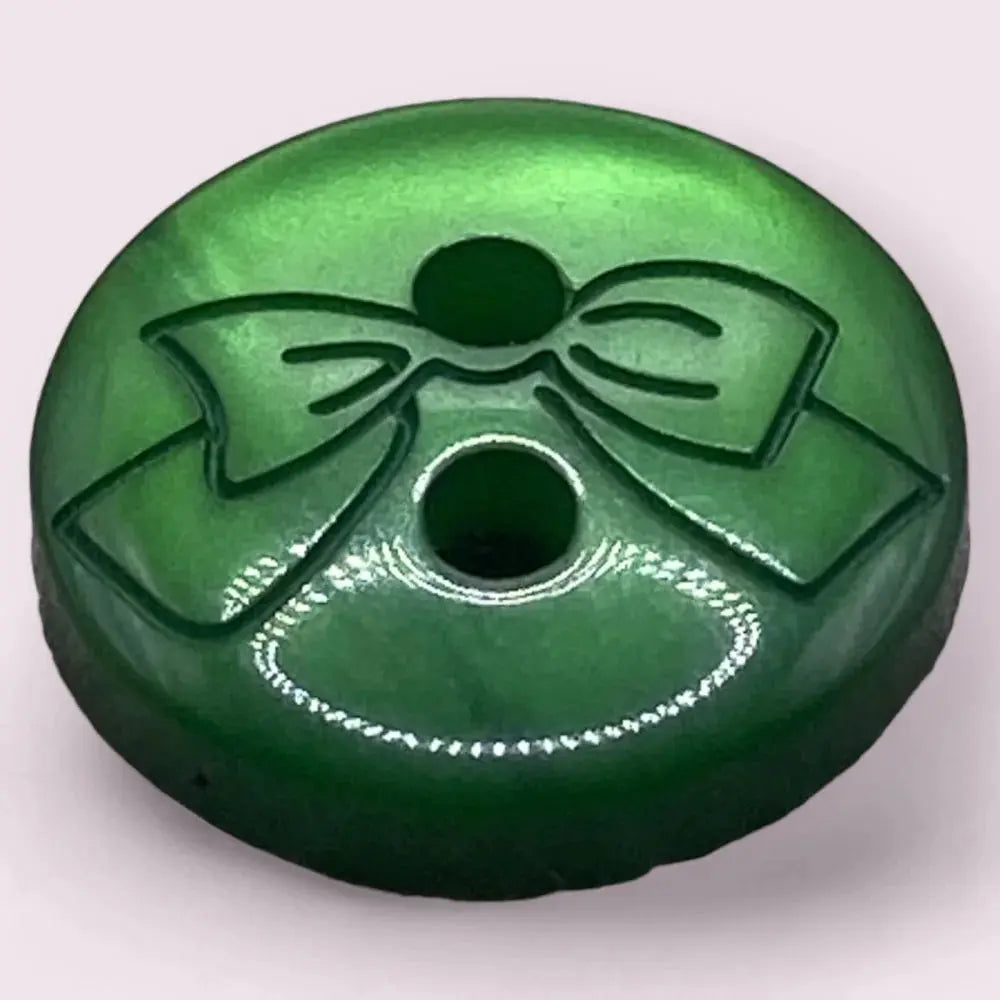 Green button with a bow design.