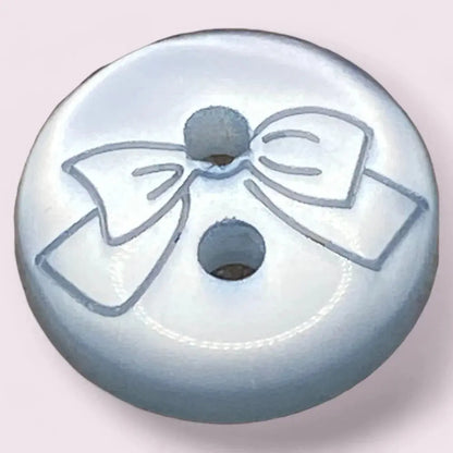 Round, light blue button with a bow design.