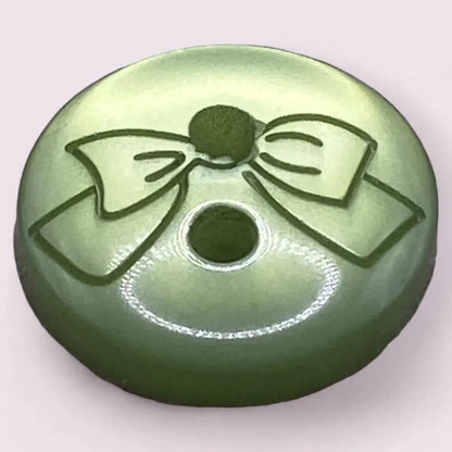 Green button with a bow design.
