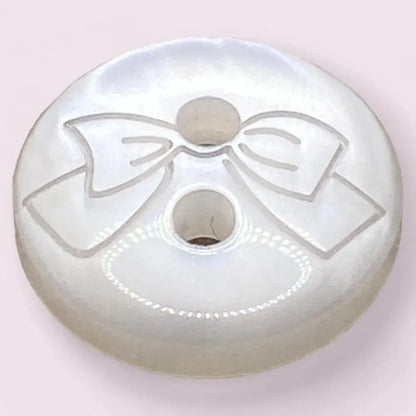 White button with a bow design.
