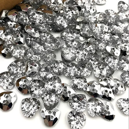 Pile of silver heart-shaped rhinestones.