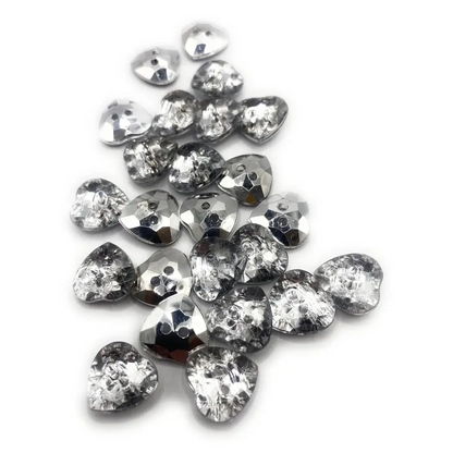Pile of heart-shaped, faceted, silver buttons.