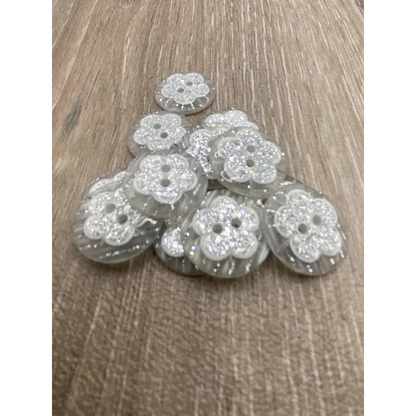 Pile of flower-shaped, glittery buttons.