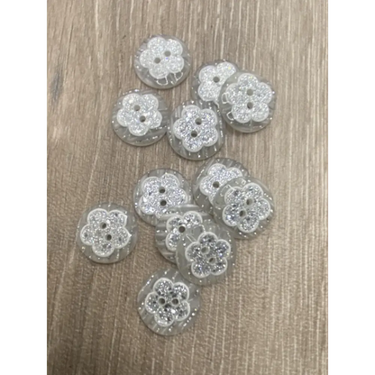 Group of flower-shaped, glittery buttons.