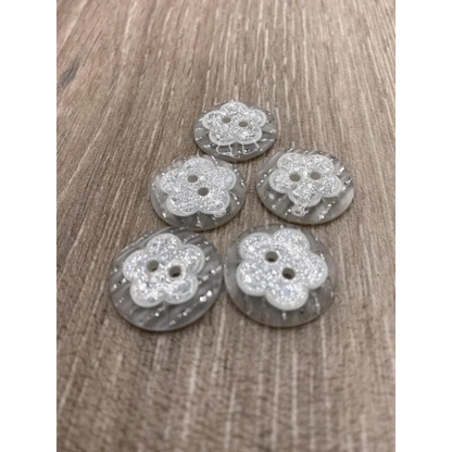 Five flower-shaped, glittery buttons.