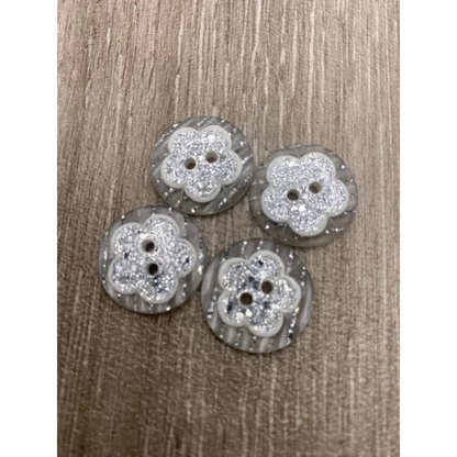 Four flower-shaped, glittery buttons.