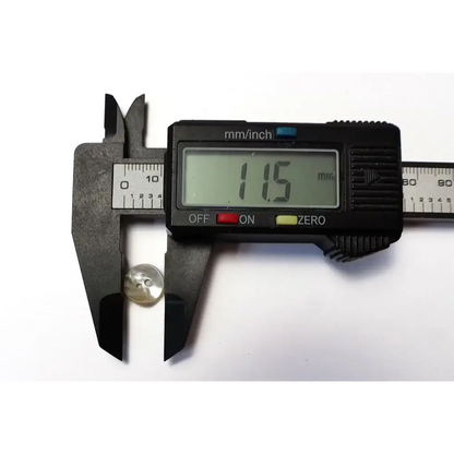 Button being measured with digital calipers.
