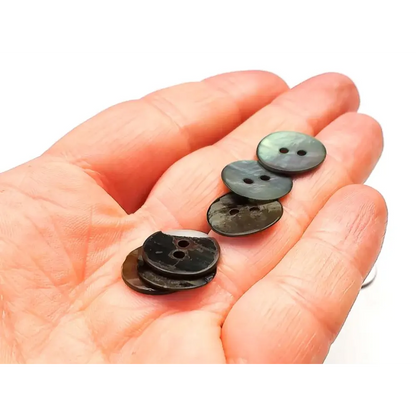 Hand holding iridescent buttons.