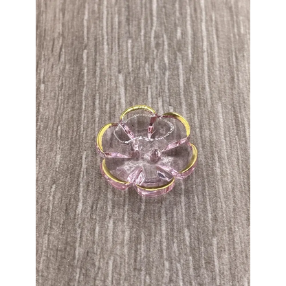 Translucent pink flower with gold trim.