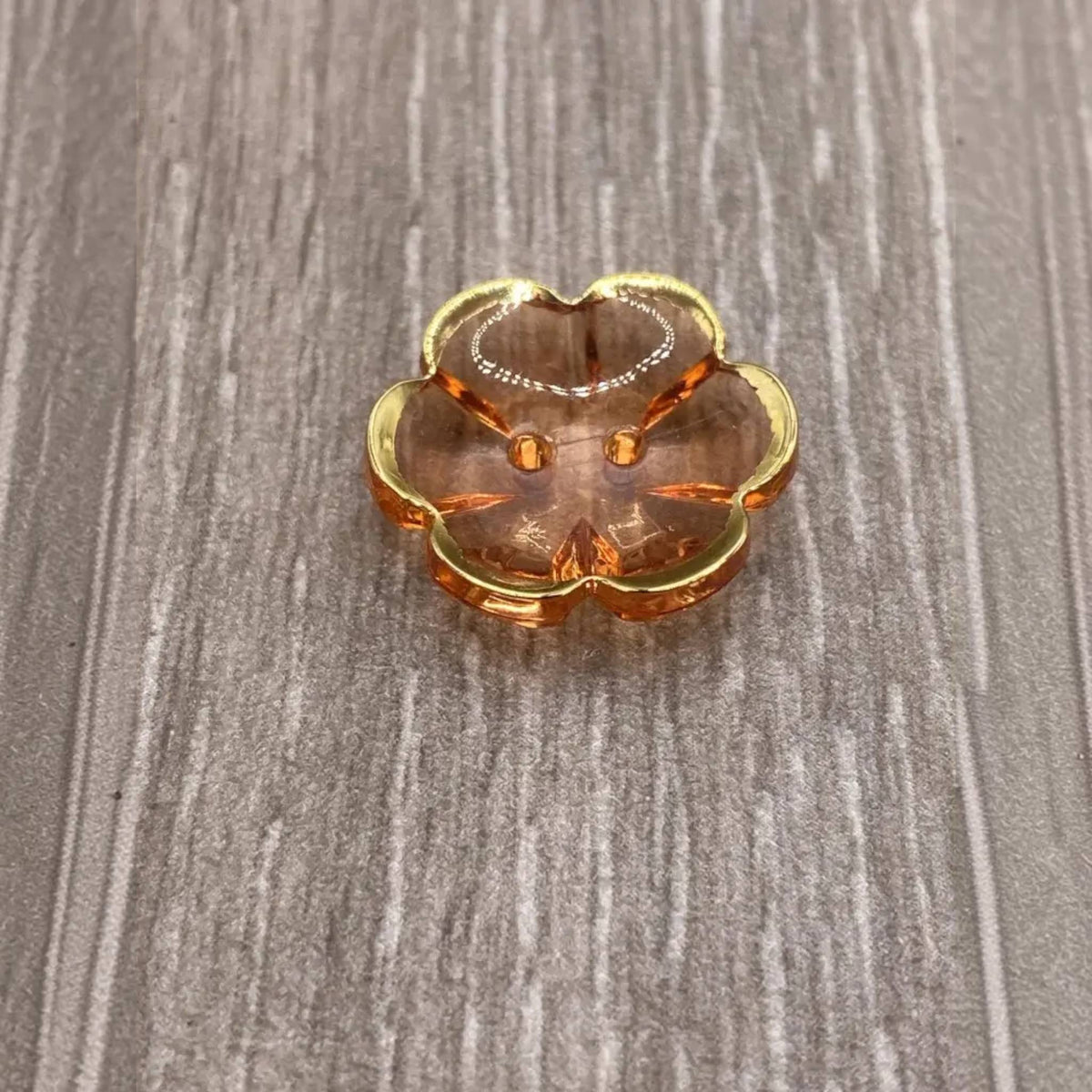 Peach-colored glass trinket dish with gold trim.