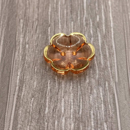 Peach-colored glass trinket dish with gold trim.