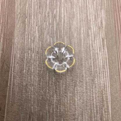 Clear flower-shaped button with yellow trim.