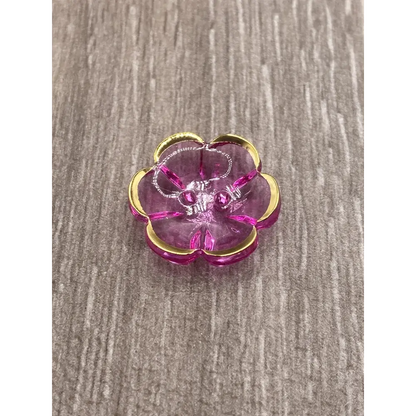 Pink and gold flower-shaped jewelry holder with jewelry.