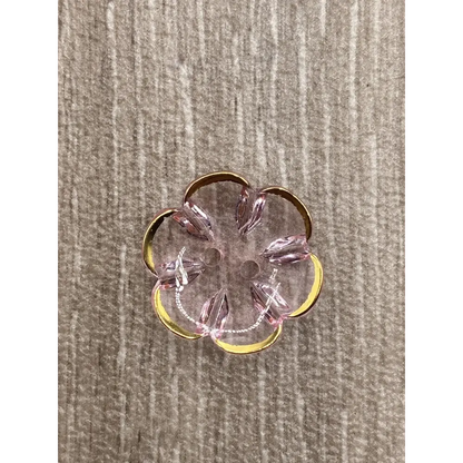 Flower-shaped, pink and gold button.