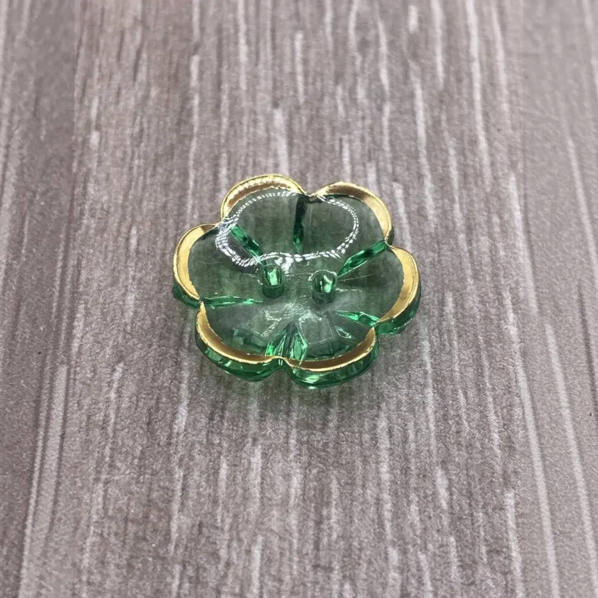 Green glass flower with gold trim.