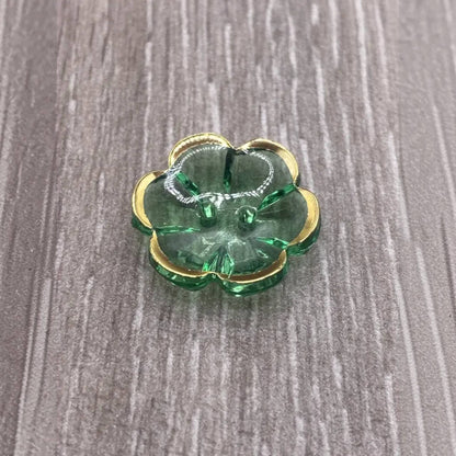 Green glass flower with gold trim.