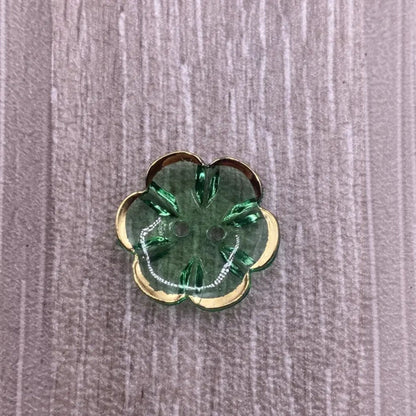 Green flower-shaped button with gold trim.