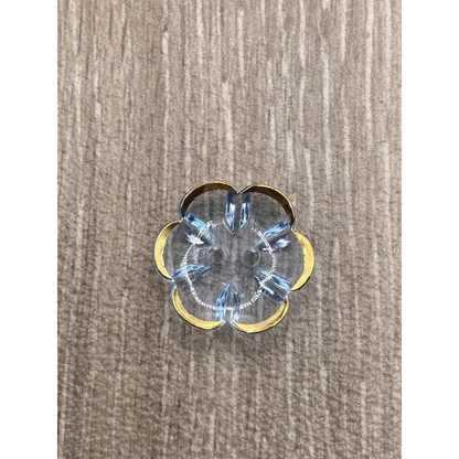 Flower-shaped, clear button with gold trim and blue crystal accents.
