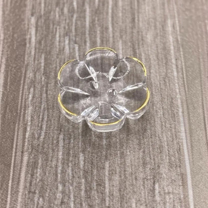 Clear glass flower-shaped dish with gold trim.