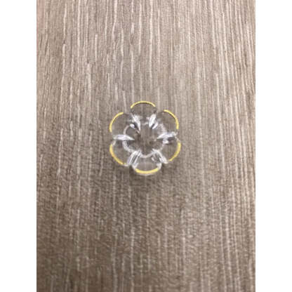Clear flower-shaped plastic embellishment with yellow trim.
