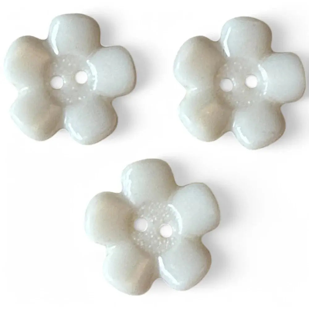 Three white flower-shaped buttons.