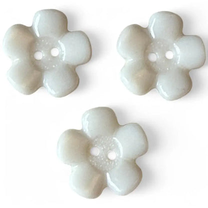 Three white flower-shaped buttons.