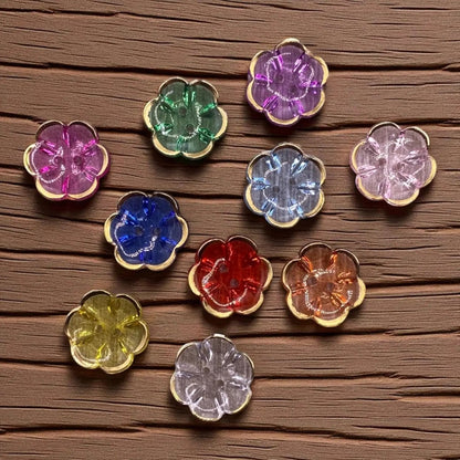 KnitForLess 13mm flower-shaped acrylic buttons in various colors with gold rims, arranged on a wooden surface.