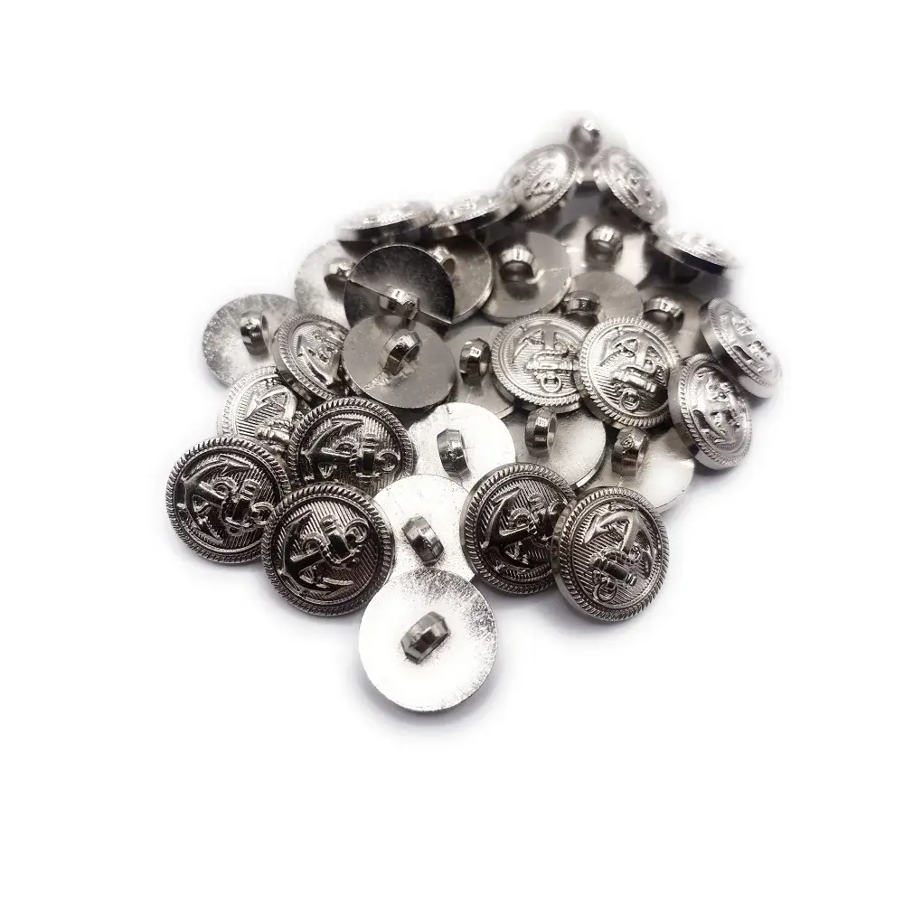 Pile of silver-colored, nautical-themed buttons.