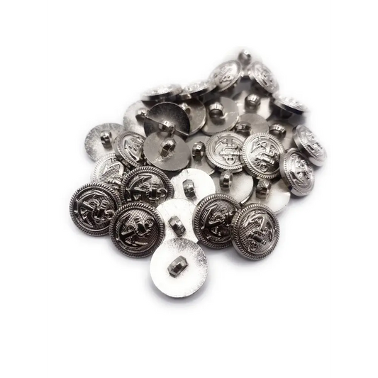 Pile of silver-colored, nautical-themed buttons.