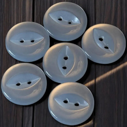 Seven white, round, two-holed buttons.
